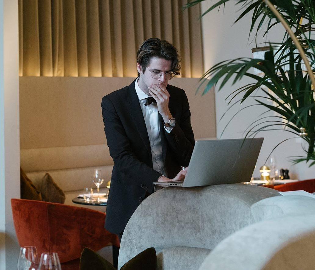 Hospitality Manager working on laptop - Get expert support and quick answers to all your questions about Resengo. Our dedicated support experts are here for you!