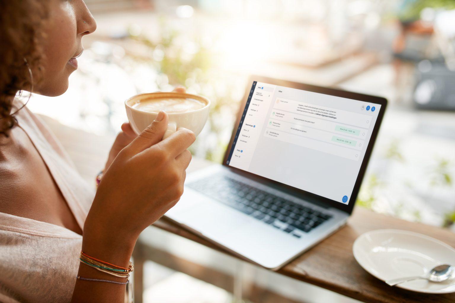 Resengo beheer je inbox - een dame met koffie bekijkt haar inbox op haar laptop.